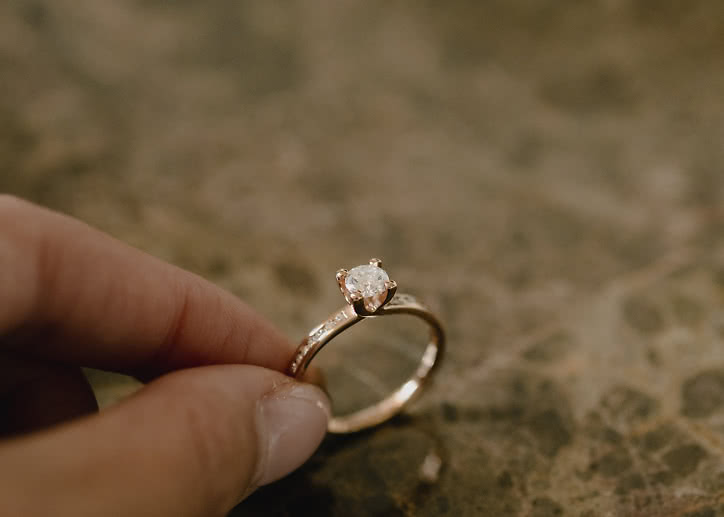 Side stone ring in 18K gold with a 0.5-carat center diamond from VANBRUUN